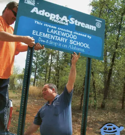 Volunteers erecting a sign for the Adopt-a-Stream program