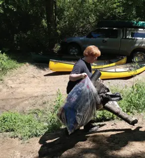 Jeff State Employee Elizabeth Little carries a bag of trash during the Jeff State ALPALS cleanup on the Cahaba River.